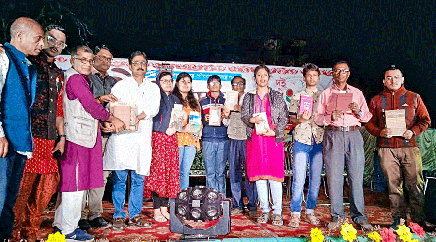 The lucky bidders with their books at the 15th Pandua Book Fair in Hooghly district on Sunday night.