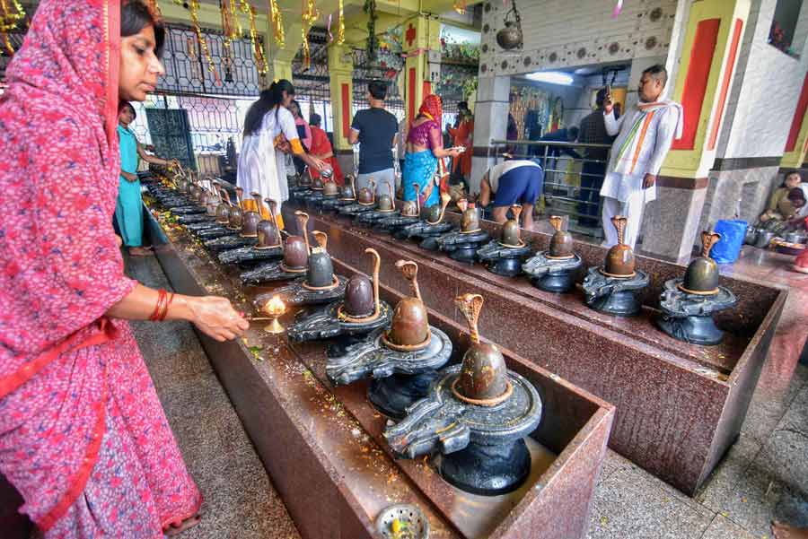 A devotee offers prayers on the occasion of Maha Shivaratri at Rani Debendra Bala Ghat on Saturday