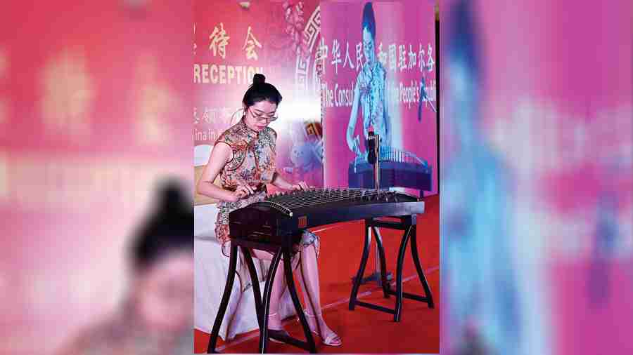 Li Shuyue, a staff member of the consulate, plays guzheng, a traditional string instrument