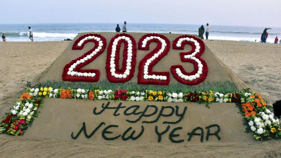 Sand artist Sudarshan Pattanaik creates a sand sculpture wishing Happy New Year, in Puri. 