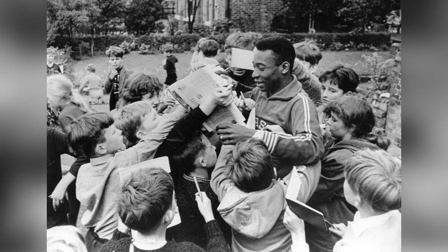 Pele, surrounded by young autograph hunters, in the UK in the 1960s