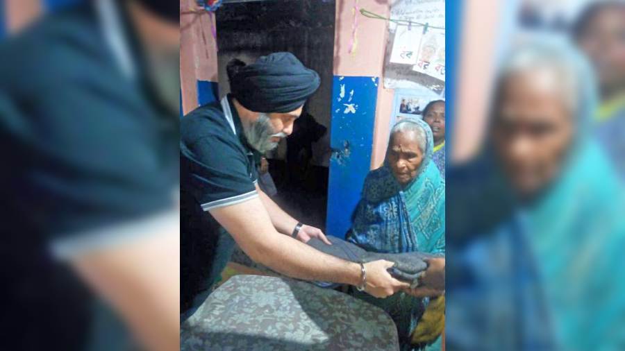 Satnam Singh Ahluwalia, founder of the IHA Foundation, gives a blanket to a shelterless resident of Bakrahat village in South 24-Parganas