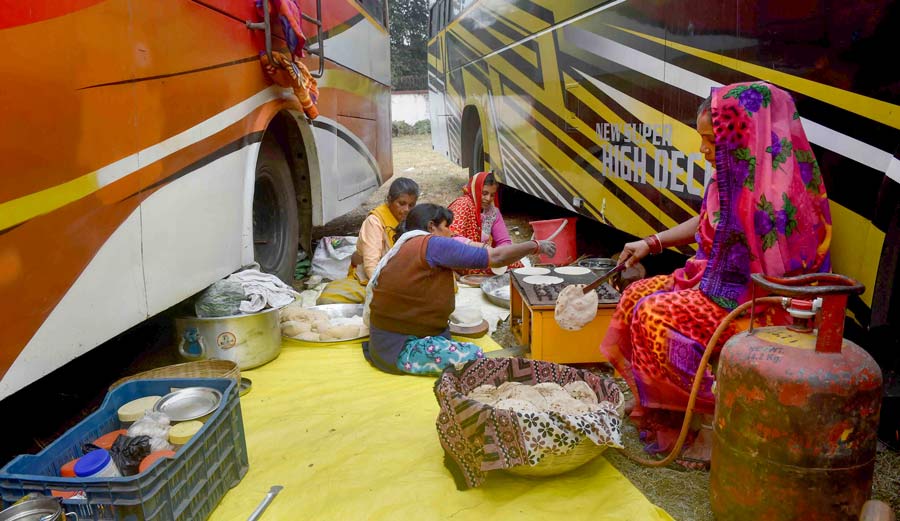 Devotees on their way to Gangasagar Mela prepare food at Babughat, Kolkata, on Monday