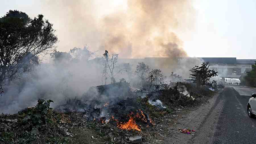 Waste, dry leaves and branches set on fire on a field in New Town on Wednesday. 