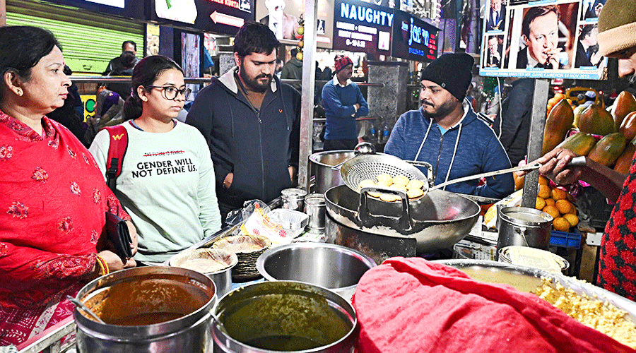 Customers enjoy street food on Camac Street on Thursday evening.