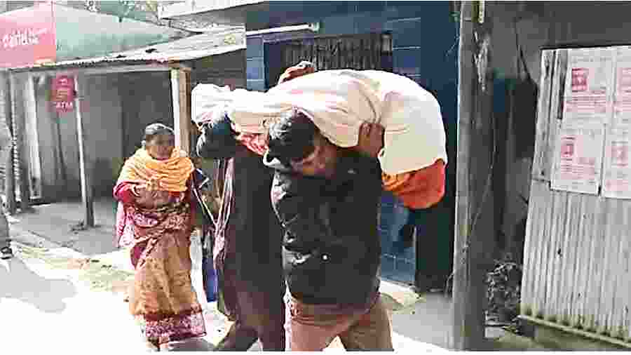 Laxmirani’s body being carried by her husband and son in Jalpaiguri on Thursday. 