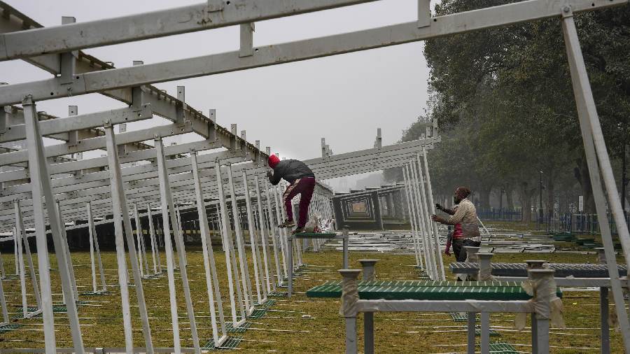 Workers prepare visitors' enclosures for RD Parade 2023 along the Kartavya Path during a cold morning. 