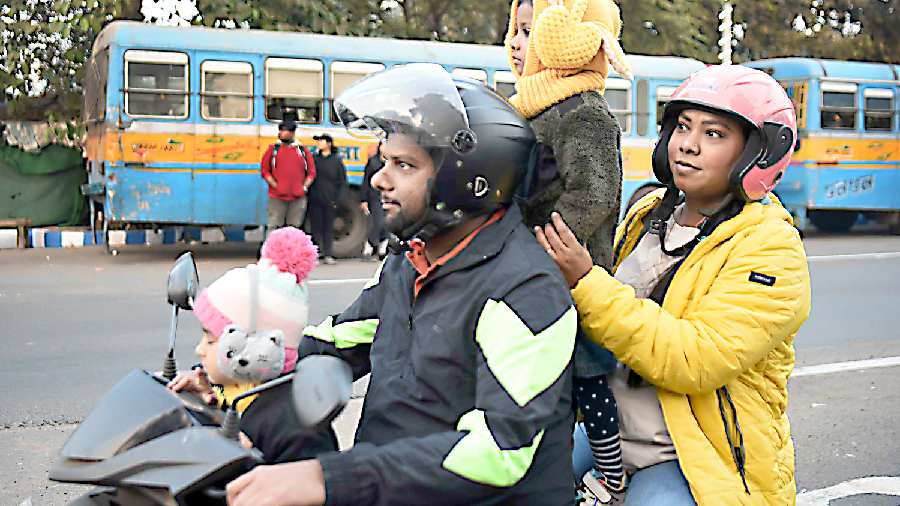 A family wrapped in woollens on a motorcycle on Mayo Road on Friday evening