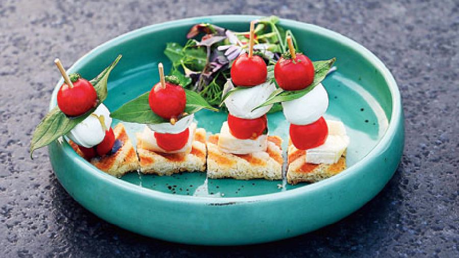 The Brie and Bocconcini Pesto Cherry Tomato Caprese Salad looks pretty and tastes fresh.
