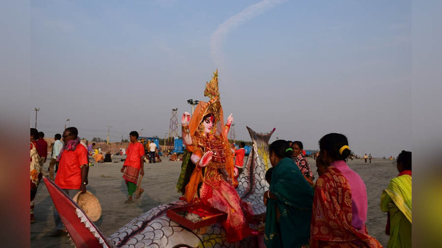 Pilgrims paying respect to deity of Ganga at the beach 