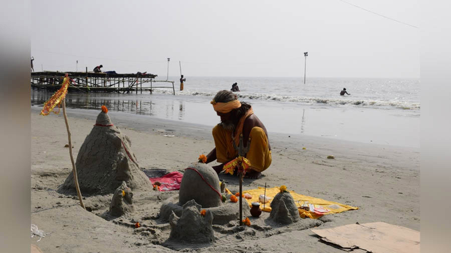 A Sadhu making a Shivling with silt and sand near the beach at Gangasagar Island