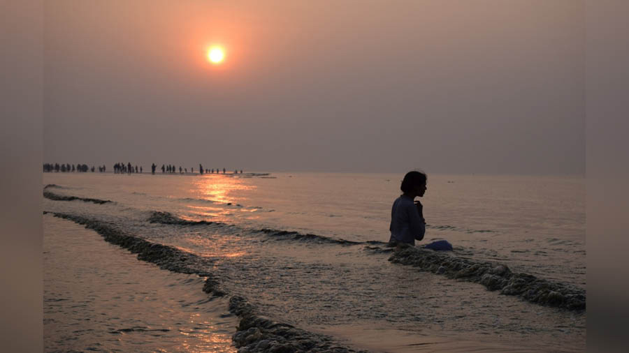 A woman taking bath in the ocean at Gangasagar fair