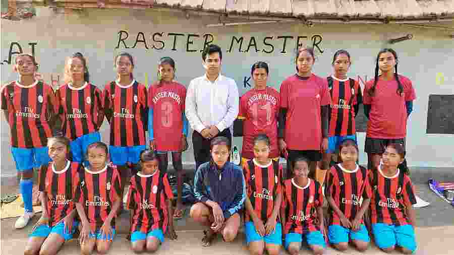 Deep Narayan Nayak with the team of women footballers in West Burdwan’s Jamuria on Friday.