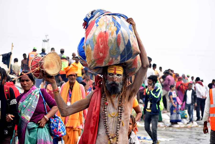 A ‘sadhu’ plays his ‘damru’ while navigating the crowd of pilgrims at Gangasagar Mela on Sagar Island. Devotees continue to throng the fair, which began on January 8