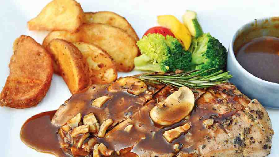 Grilled Chicken with Mushroom Sauce: Dig into this delicious dish of juicy chicken breast accompanied with mushroom sauce, veggies and crisp potato wedges.