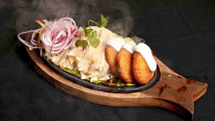 The Astor, Kolkata is already known for its kebab and this smokey treat with Dahi Kebab is a show of strength and an interesting cross between a sizzler and a kebab. It is served with Warqi Paratha, also known as lachha paratha, and house salad of macerated onions, carrots and beetroot slices.