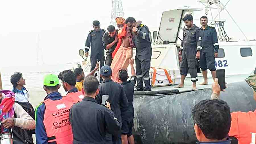 Coast Guard personnel help a rescued Gangasagar pilgrim alight from a hovercraft at Kakdwip on Monday afternoon. Two Coast Guard hovercrafts rescued 511 passengers, many of them pilgrims, from a couple of ferries that ran aground near Kakdwip on Sunday night. The ferries, which were on their way to the mainland from Sagar Island, ran aground during  low tide and amid dense fog.