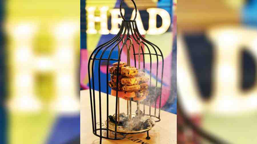 Achari Paneer Tikka is served in a bird cage with live coal to give the paneer tikka a smoked flavour.