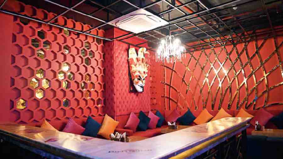 This private-dining lounge in gold and red with a honeycomb wall has a L-shaped sofa with colourful cushions, a marble bar counter top, volto or carnival masks and is well lit with a chandelier. It makes for the perfect corner to add the luxurious vibe to birthday parties, ladies’ nights, bachelorettes and more.