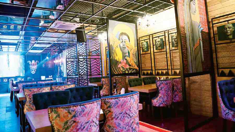 The fine-dining area has enclosed booths embellished with metal heads and vivid and visually attractive paintings dividing the booths.