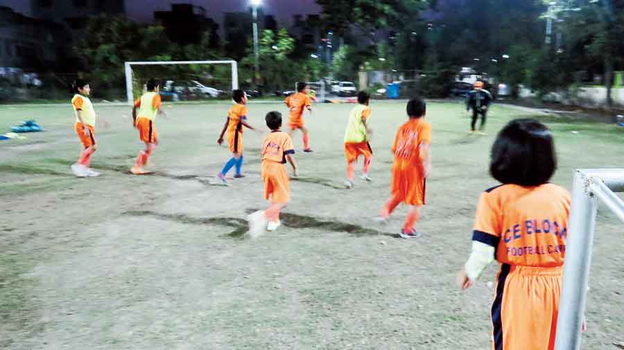 Children play under lights at the CE Block coaching camp. 