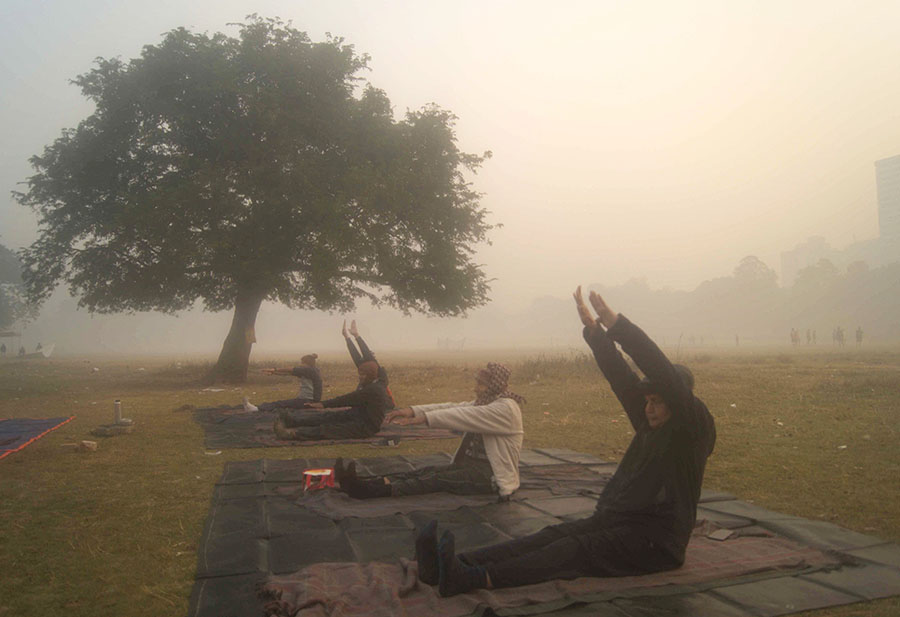 Morning walkers exercise at a fog-covered Maidan on early Saturday