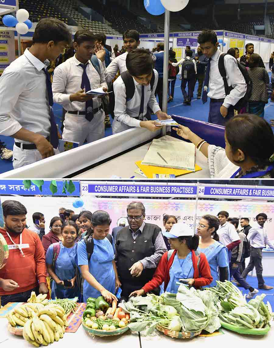 School students check out the Sufol Bangla stall and collect booklets about citizen rights at Kreta Suraksha Mela being held at Netaji Indoor Stadium on Thursday