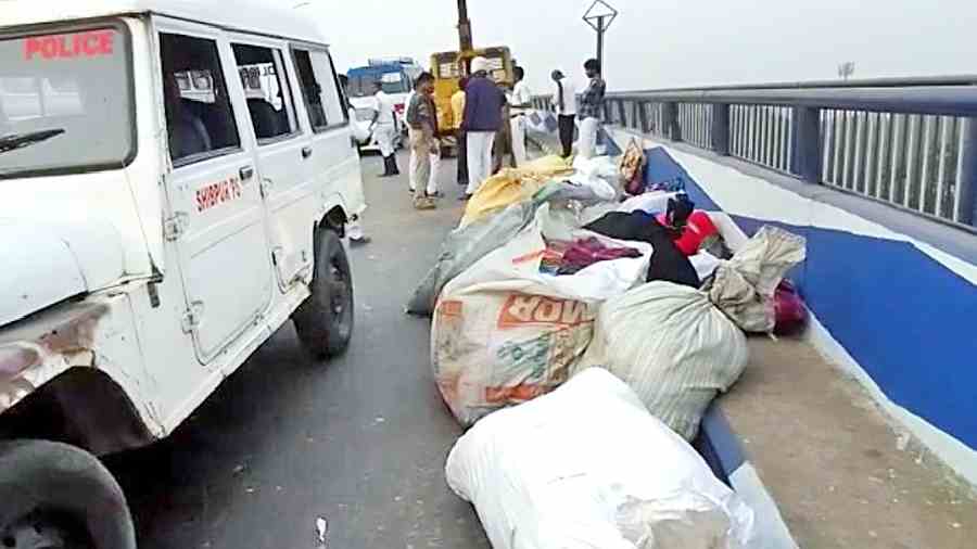 Bundles of fabric, which fell from the vehicle ferrying the injured, being removed from Vidyasagar Setu on Sunday