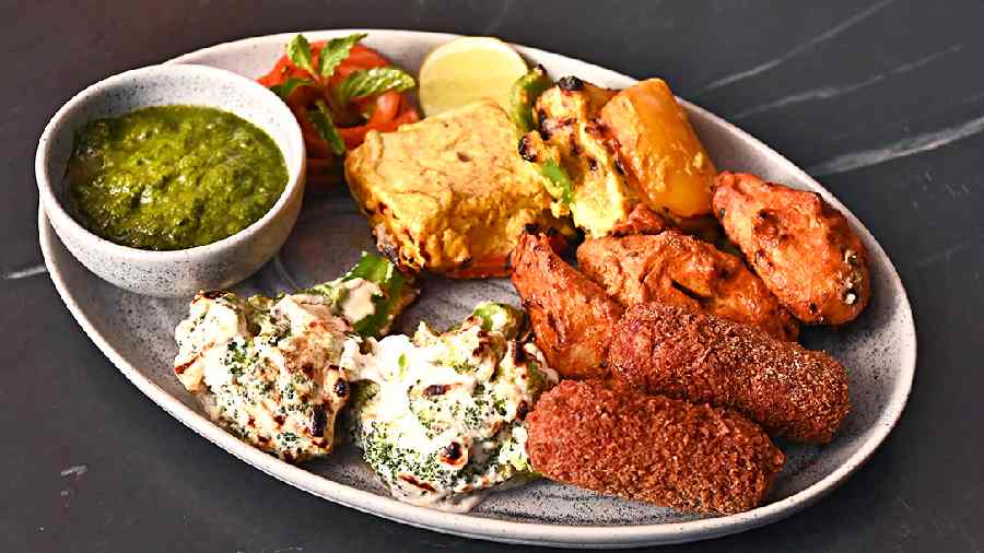 The Vegetarian Platter has an assortment of snacks such as Paneer Tikka, Tandoori Aloo, Malai Broccoli and Veg Croquettes with a fresh green chutney