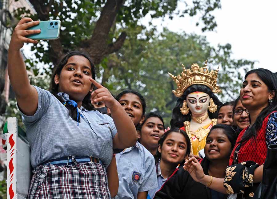 Animated with excitement for Saraswati Puja, school students take a moment to click a selfie as they bring an idol of Goddess Saraswati from Kumartuli to their school