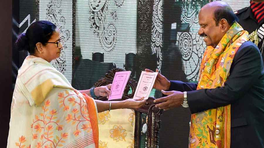 West Bengal Governor C.V. Ananda Bose receives 'Barnaparichay' book from West Bengal Chief Minister Mamata Banerjee during the 'Hatey Khari' event at Raj Bhavan in Calcutta