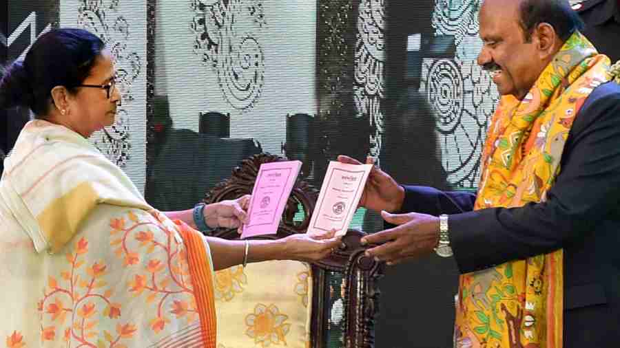 West Bengal Governor C.V. Ananda Bose receives 'Barnaparichay' book from West Bengal CM Mamata Banerjee during the 'Hatey Khori' event at Raj Bhavan in Kolkata on Thursday.