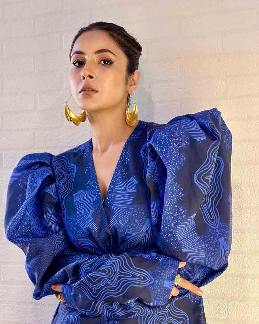 Shehnaaz loves wearing blue and turned up the bar in a graphic print blazer with pointed shoulders, matching pants and golden earrings. 