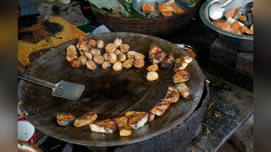 Fish pieces and half-split littis on the frying pan 