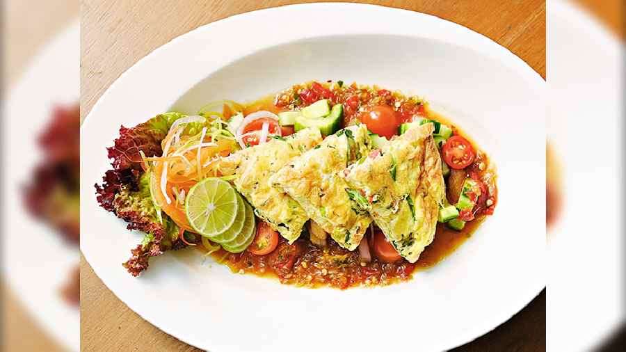 Yam Khai Dao Baan Thai: Baan Thai omelette salad with onion, cucumber and tomato, in chilli garlic dressing. This is a Thai speciality dish and is a very popular street food.