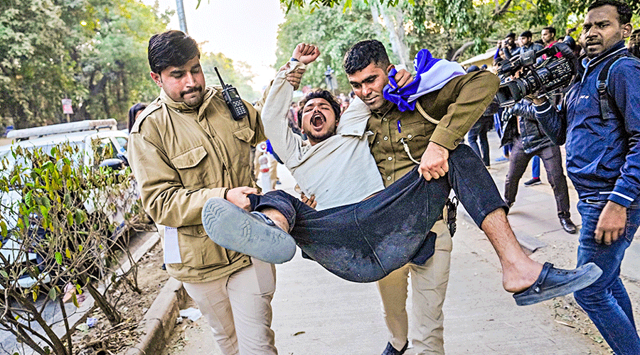 Policemen detain a student at Delhi University Arts Faculty on Friday. 