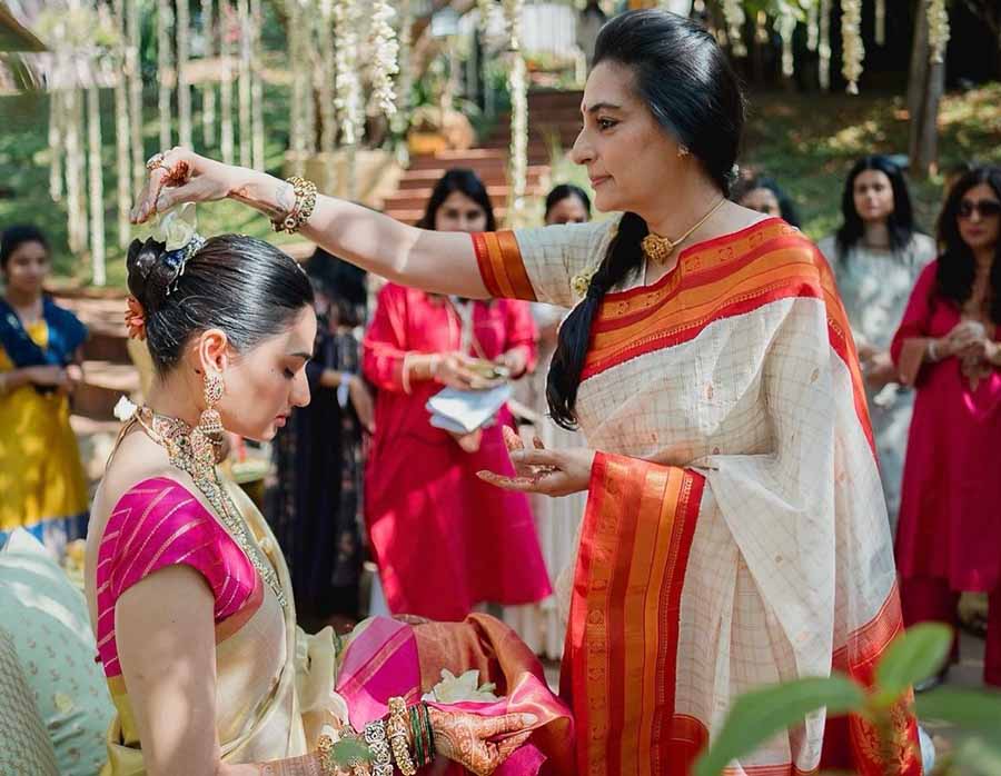 Athiya’s mother, Mana Shetty, was dressed in a simple white-and-red sari as she performed a ritual. 