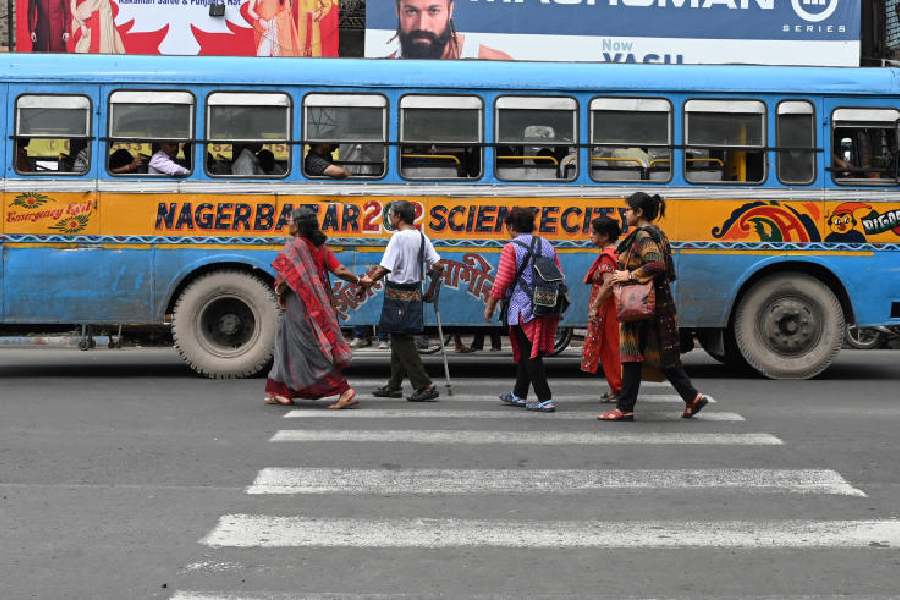 A bus stops well past the zebra crossing at a signal, forcing pedestrians to make a detour from behind the vehicle, in Shyambazar on Friday afternoon