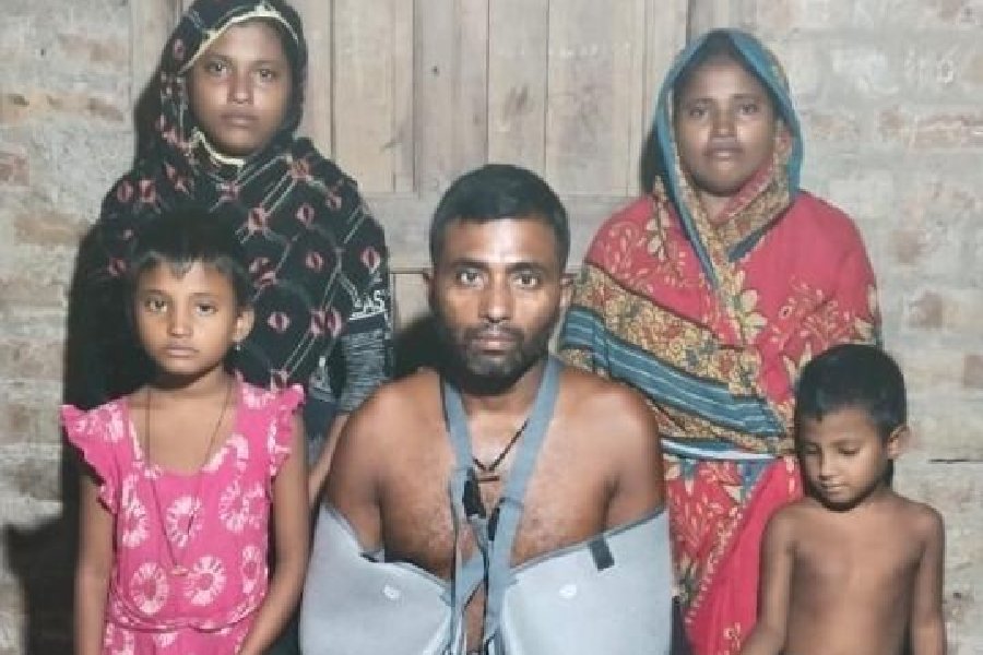 Ibrahim Sk with his wife Sabina Bibi (standing, right) and their three daughters at their home in Kakdwip’s Madhusudanpur on Tuesday evening
