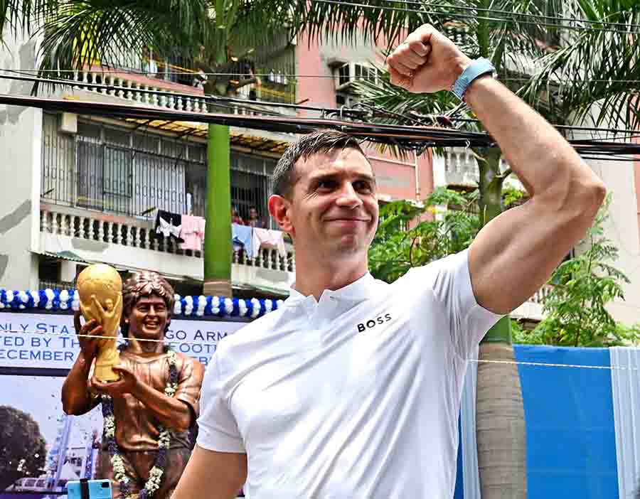 FIFA World Cup 2022 winning team member Argentinian Emiliano Martinez pumps his fist in the air after paying floral tributes to a statue of Diego Armando Maradona in Kolkata on Wednesday