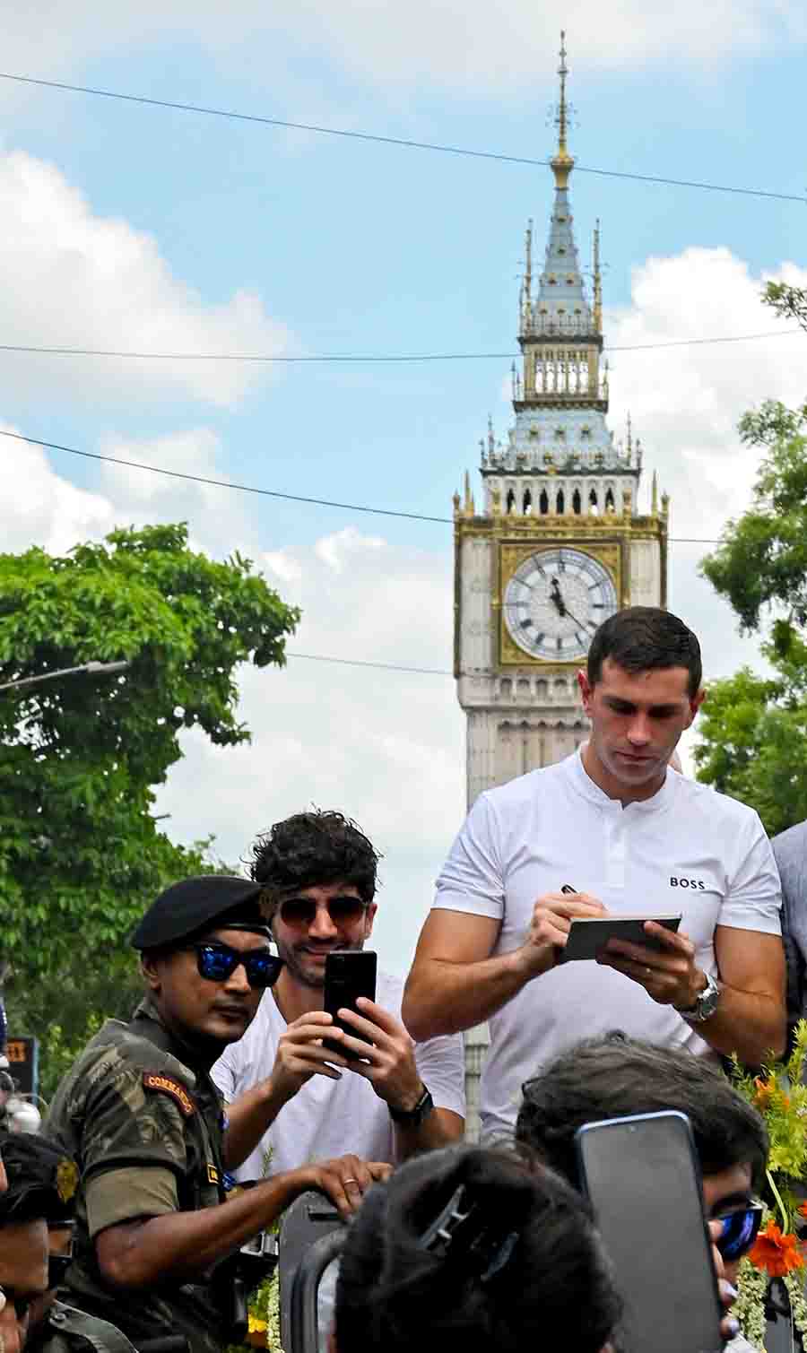 Emiliano Martinez obliges an autograph-seeker among a sea of football enthusiasts in front of the Big Ben on VIP Road