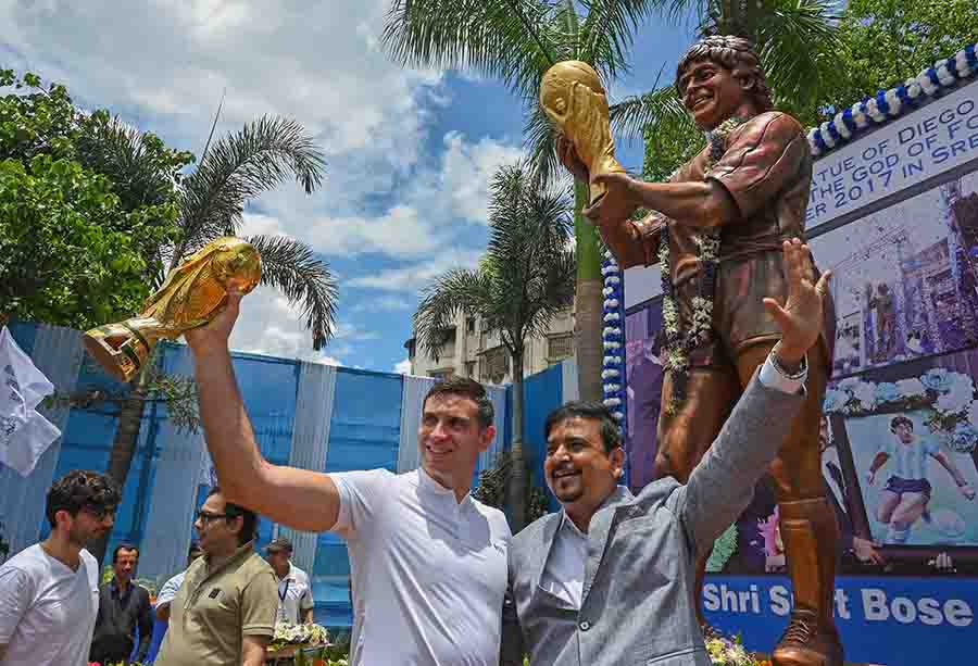 The star footballer, flanked by West Bengal fire and emergency services minister Sujit Bose, holds a replica of the Football World Cup 2022 and plays to the crowd of admirers