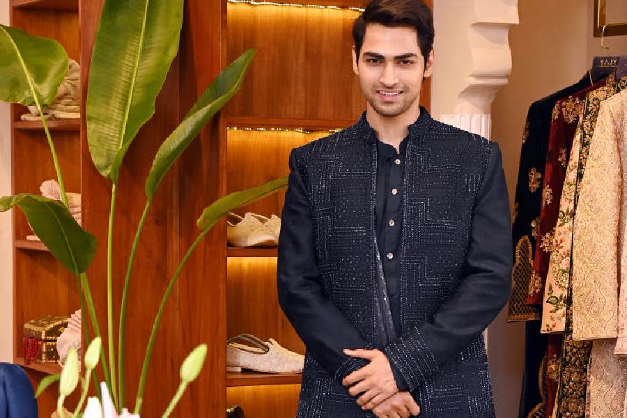 For cocktails/sangeet, go for this spiffy midnight blue handembroidered silk open jacket, paired with a monotone drape kurta with colour block drape and ankle-length trousers.