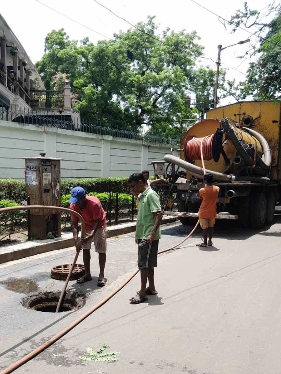 Frontline workers of the Kolkata Municipal Corporation’s sewerage and waste management department operate jet-cum-suction machine to clear a gully pit for smooth flow of waste water 