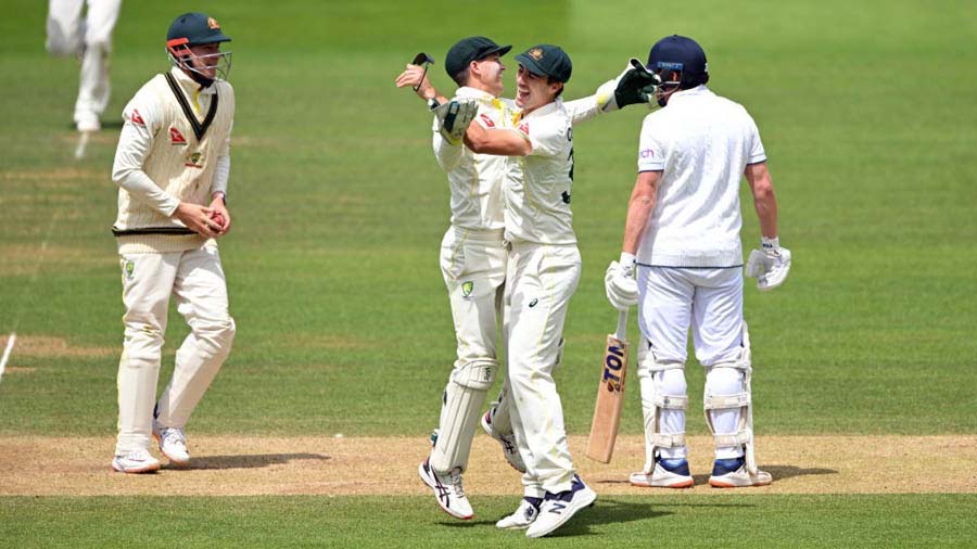Australia wicketkeeper Alex Carey and Pat Cummins celebrate after running out England batsman Jonny Bairstow