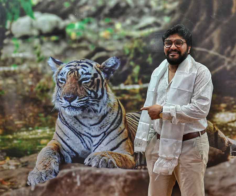 Babul Supriyo sportingly points out to a Royal Bengal Tiger on a giant poster at the fair