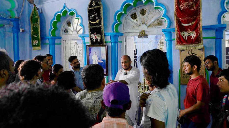 Shaikh Sohail speaks to participants of heritage walk inside Sibtainabad Imambara. Behind the arches is the final resting place of Nawab Wajid Ali Shah