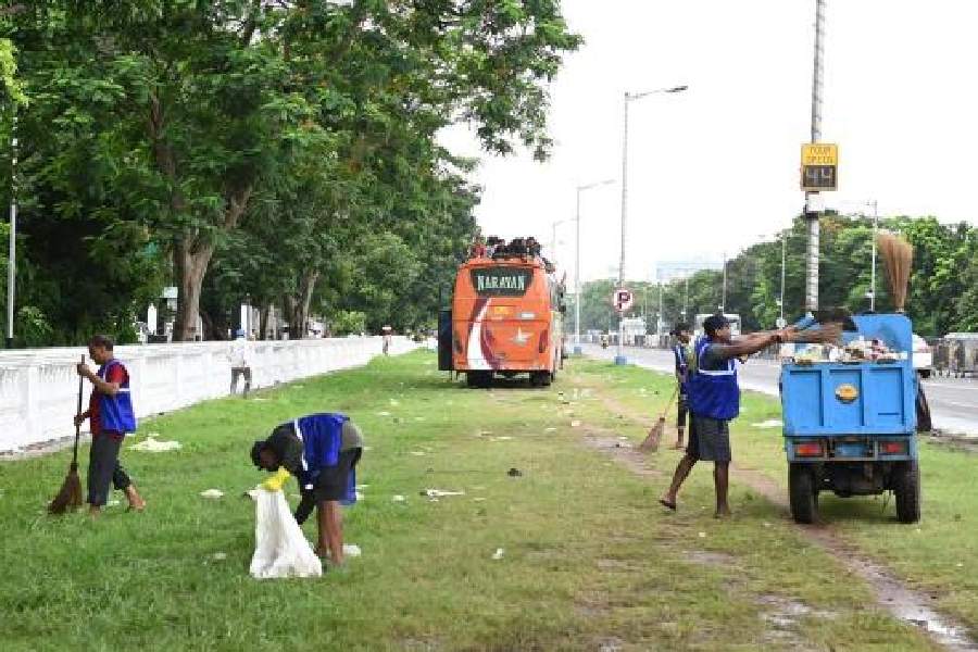KMC workers remove garbage from along Red Road after the Martyrs’ Day rally on Friday