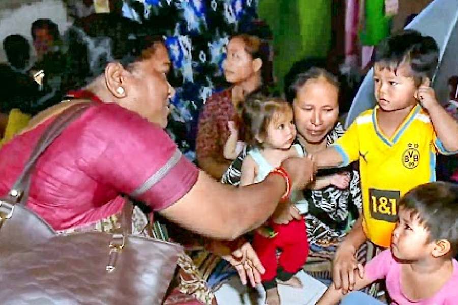 Congress MP Phulo Devi Netam interacts with children at a relief camp in Churachandpur district on Saturday.