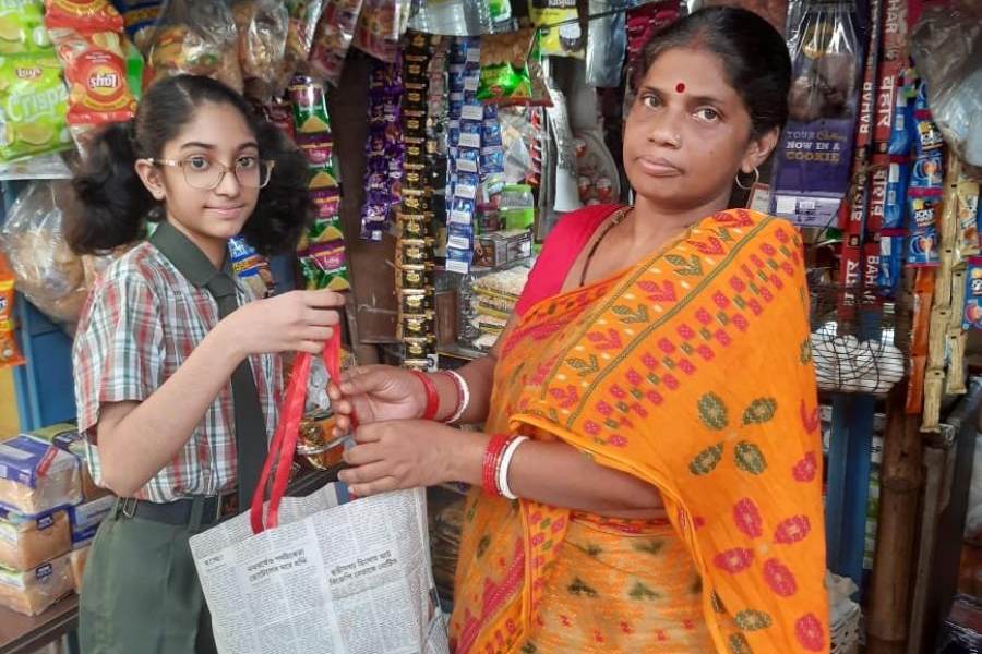 Sreeja Ganguly, a student of Class VI at BDM International, hands paper bags to the owner of a grocery store in her neighbourhood as part of her summer vacation project